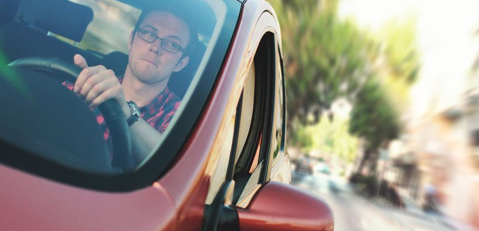 Photo d’un homme au volant d’une voiture rouge