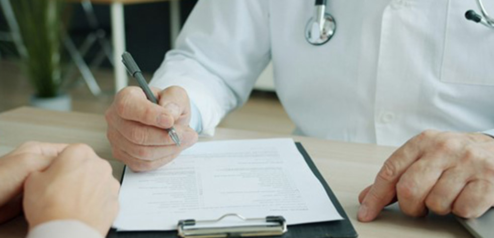 Photo d’un médecin remplissant le dossier d’un patient