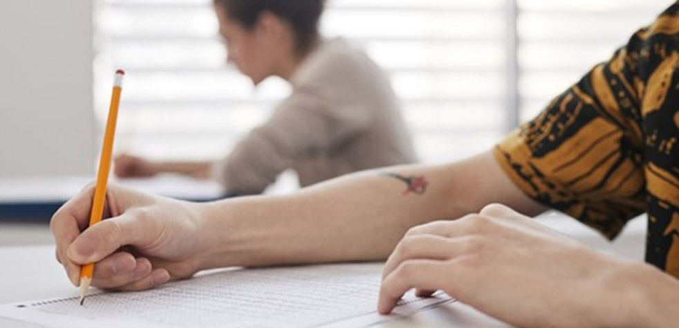 Photo d’une personne prenant des notes sur un document