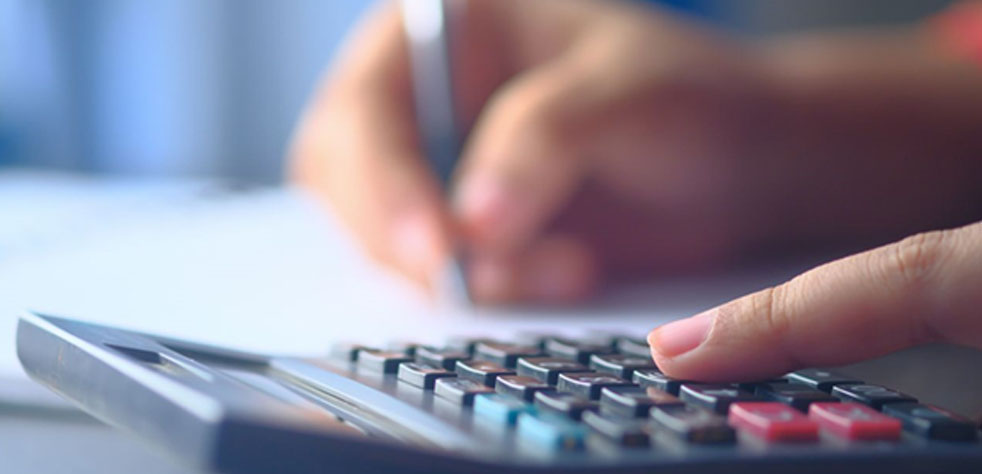 Photo d’une main manipulant une calculatrice